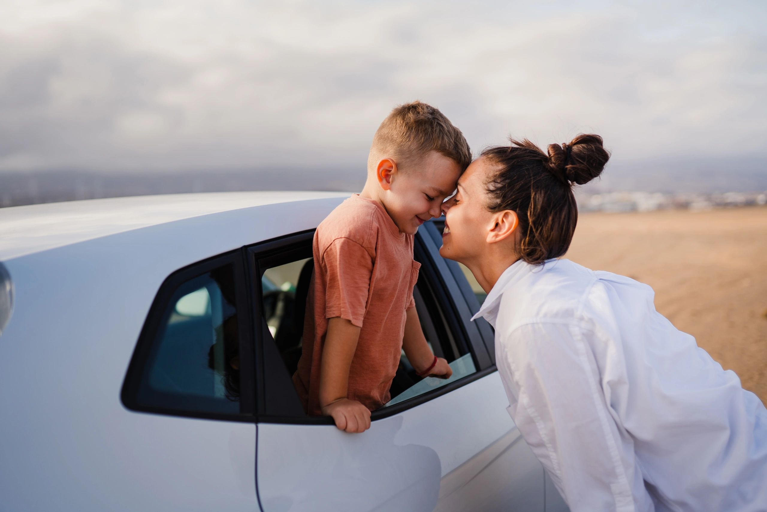 KindRide driver greeting child at the car with a smile